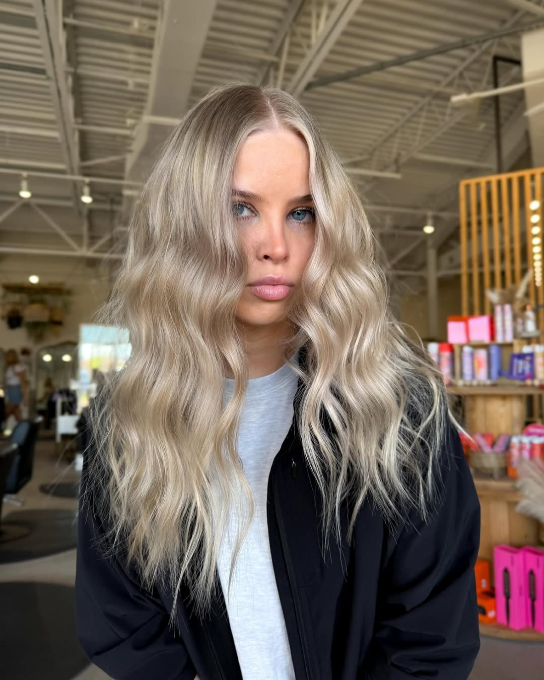 Beautiful woman with sun-kissed blonde hair styled in loose beach waves, perfect for summer hair ideas women 2026. She wears a flowy white dress at a beach party.