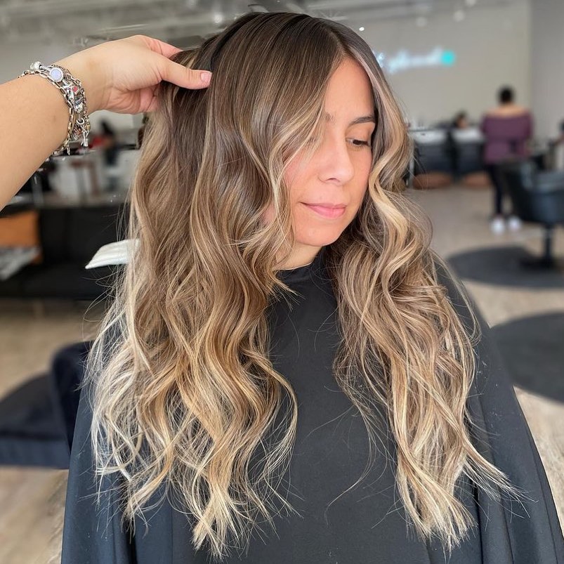 Beautiful woman with long, flowing waves, showcasing elegant summer hair ideas women 2026 for a chic daytime look.