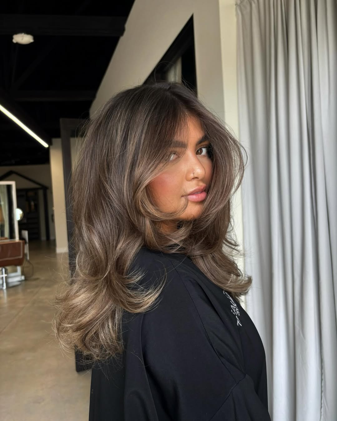 Blonde woman with sun-kissed ombre hair in loose waves, perfect for summer hair ideas women 2026. This casual, effortlessly chic style is ideal for beach days or outdoor events.