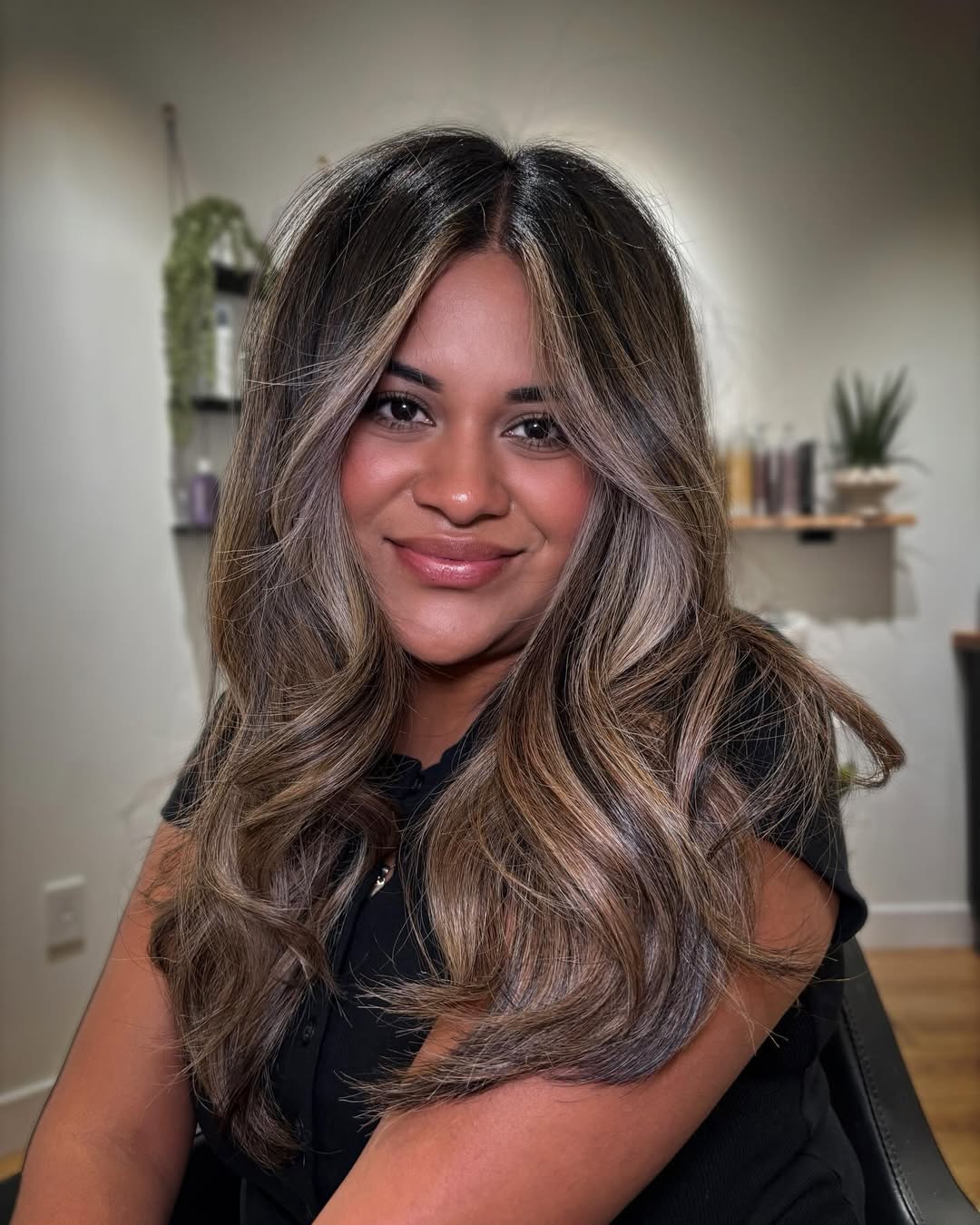 Close-up of a woman with long, textured brown hair styled in soft, natural waves, showcasing chic summer hair ideas women 2026 for a relaxed, elegant look.