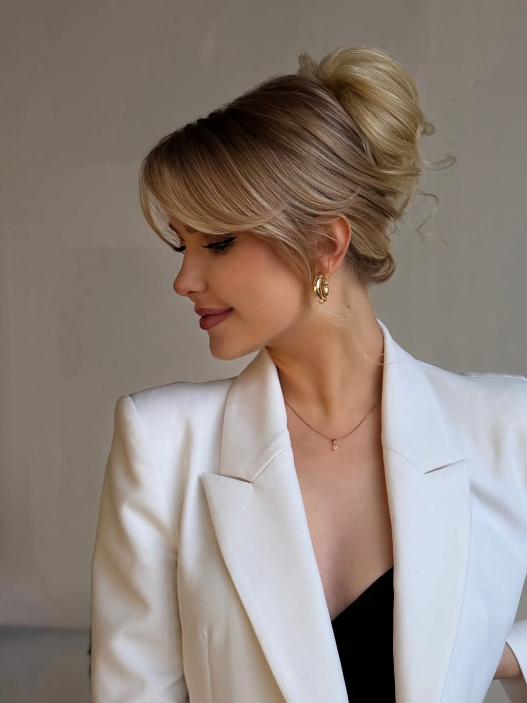 Woman with long, wavy blonde hair styled in a half-up twist with face-framing tendrils, perfect for summer hairstyles long hair ideas 2026.