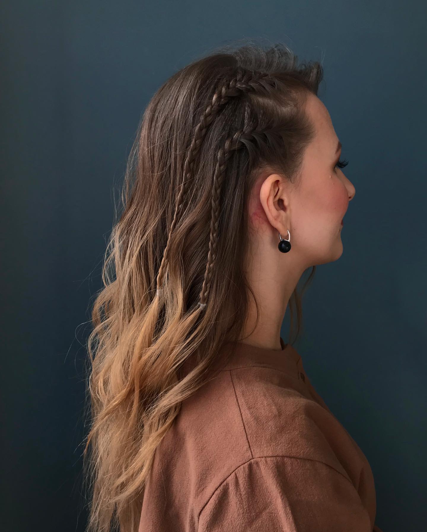 Beautiful woman with long, sun-kissed hair styled in a loose, voluminous side braid, perfect for summer hairstyles long hair ideas 2026. She wears a flowy white sundress.