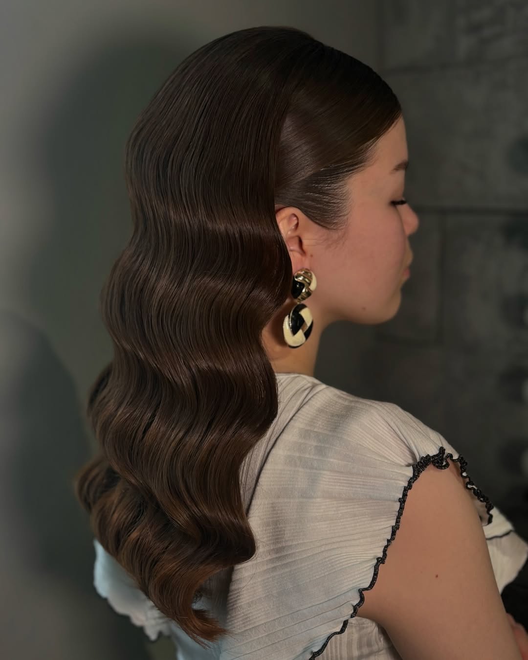 A smiling teenage girl with a half-up messy bun, perfect for summer hairstyles teenage girls 2026. Her blonde hair is casually tied with loose face-framing pieces, ideal for a relaxed daytime look.