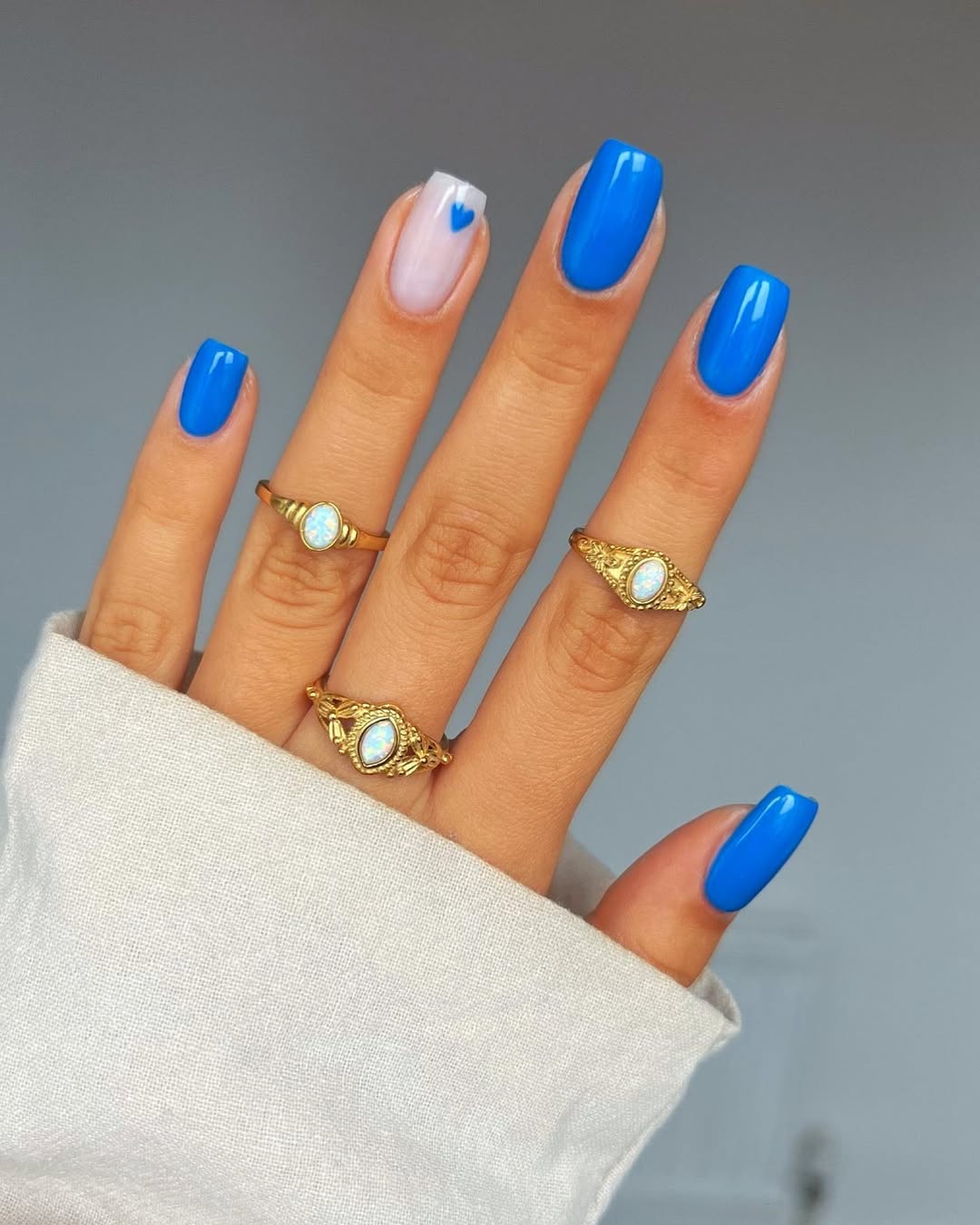Vibrant Blue Glossy Nails With Tiny Heart Accent