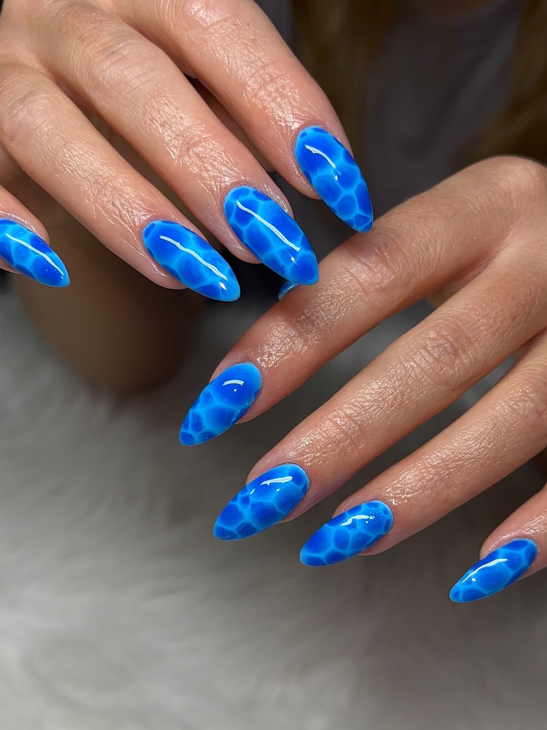 Vibrant Blue Water Effect Almond Nails