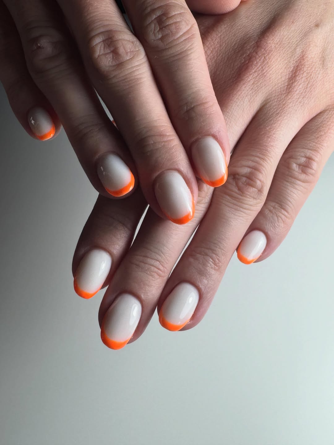 Vibrant Orange Tips on Milky White Short Oval