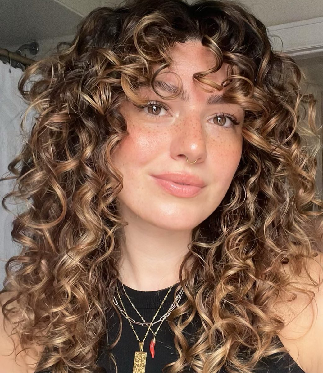 Caramel Highlights On Curly Shoulder-Length Layers
