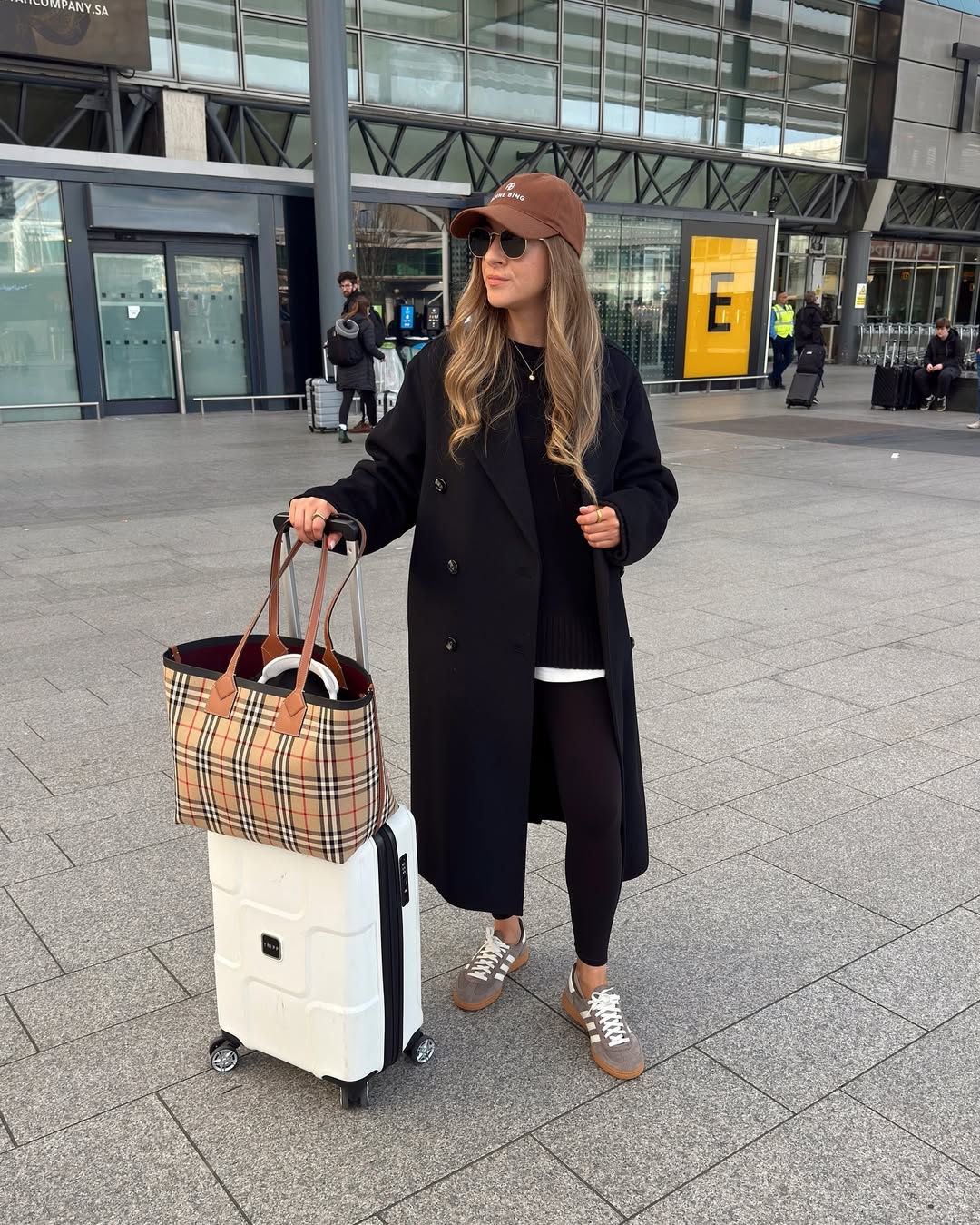 Chic Travel Look: Black Coat, Leggings, and Plaid Tote