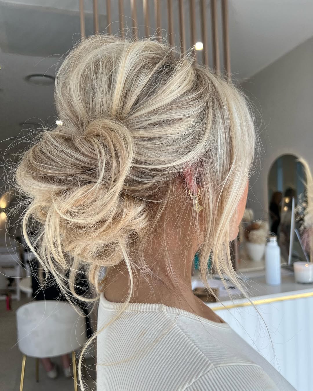 Messy Updo With Face-Framing Platinum Blonde Strands