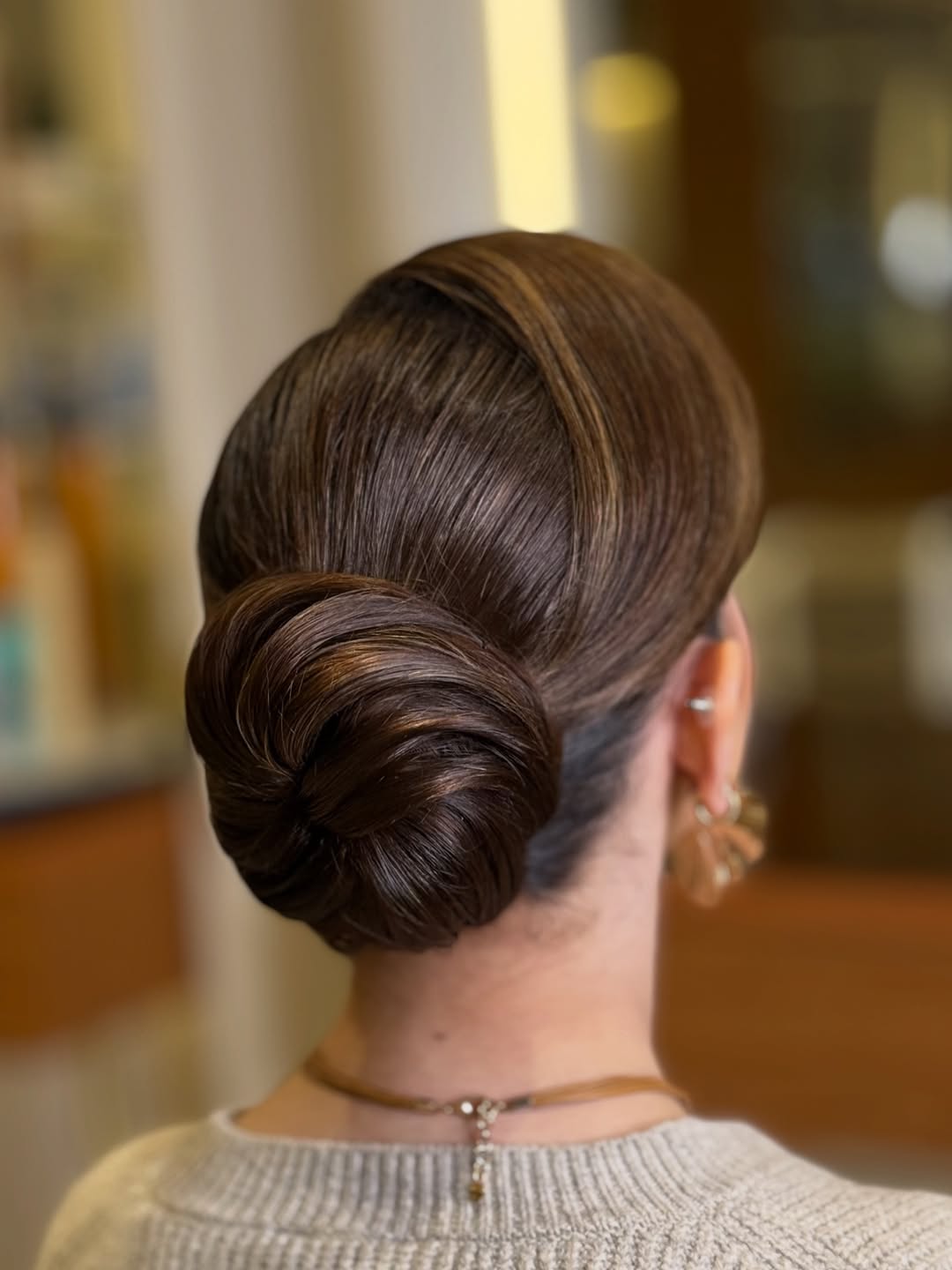 Sleek Low Bun With Golden Brown Highlights