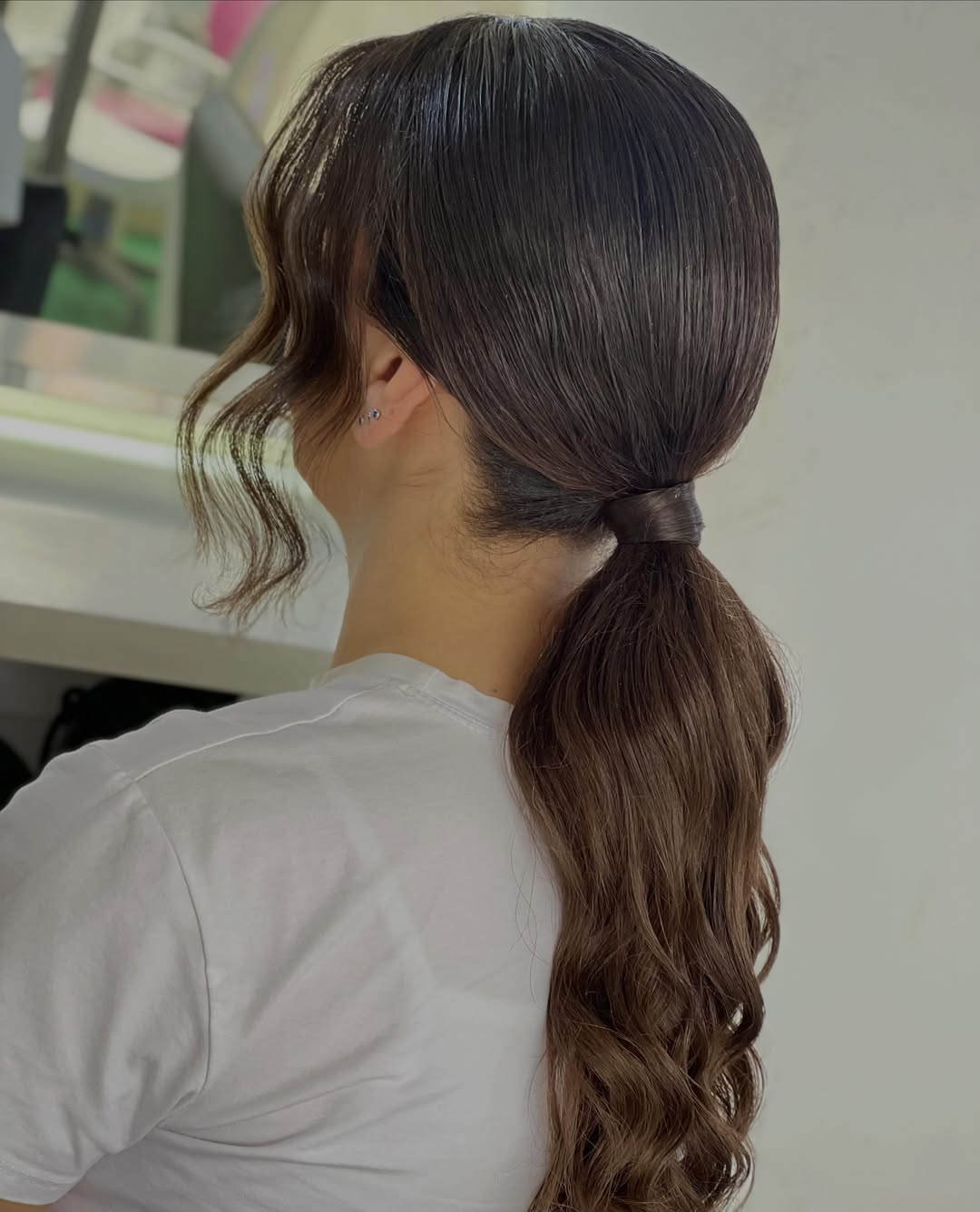 Sleek Low Ponytail With Wavy Face-Framing Tendrils