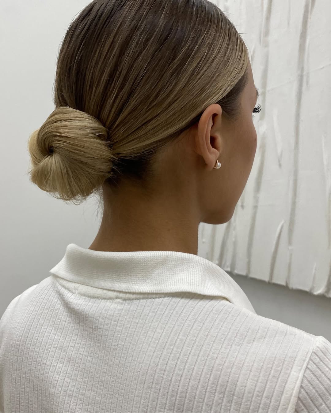 Sleek Low Twisted Bun With Honey Blonde Highlights