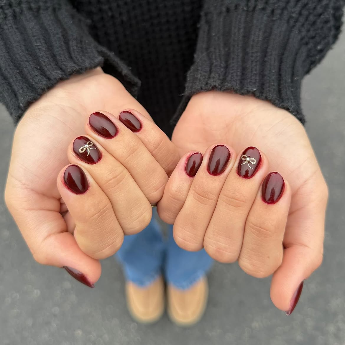 Deep Red Oval Nails with Gold Bow Accent