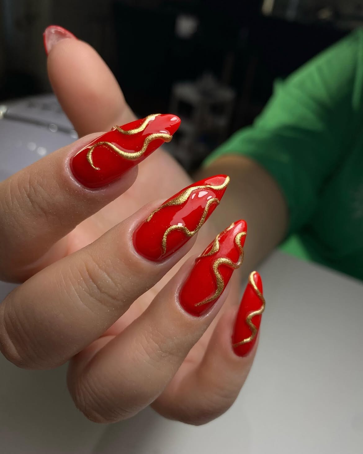 Fiery Red Stiletto Nails with Gold Swirls