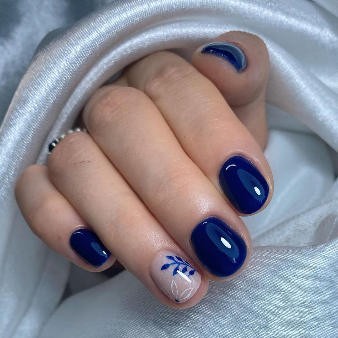 Glossy Deep Blue Oval Nails With Floral Accent