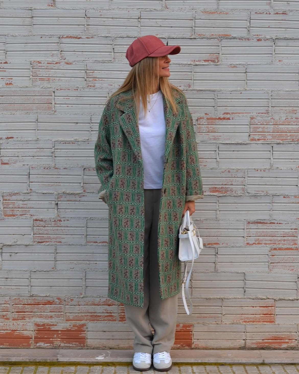 Patterned Coat With Neutral Trousers And Baseball Cap