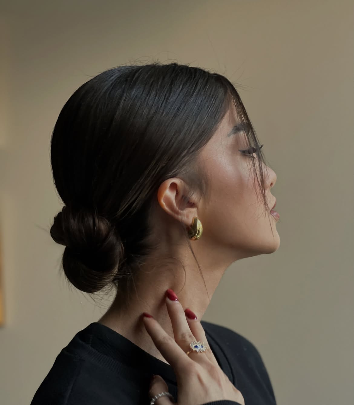 Sleek Double Low Buns With Wispy Face Framing Strands