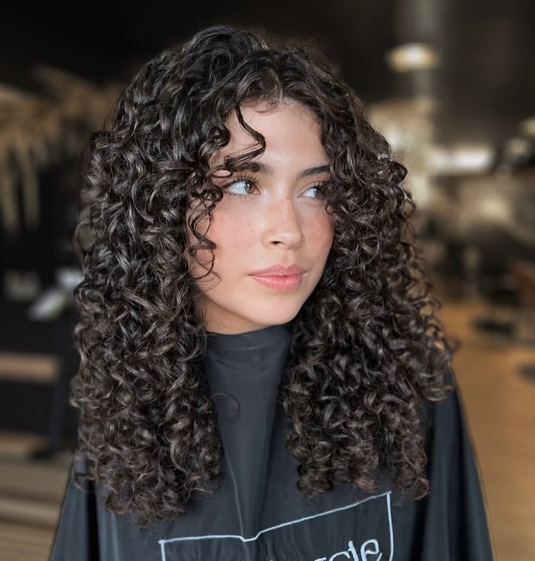 Defined Curly Layers With Face Framing Fringe