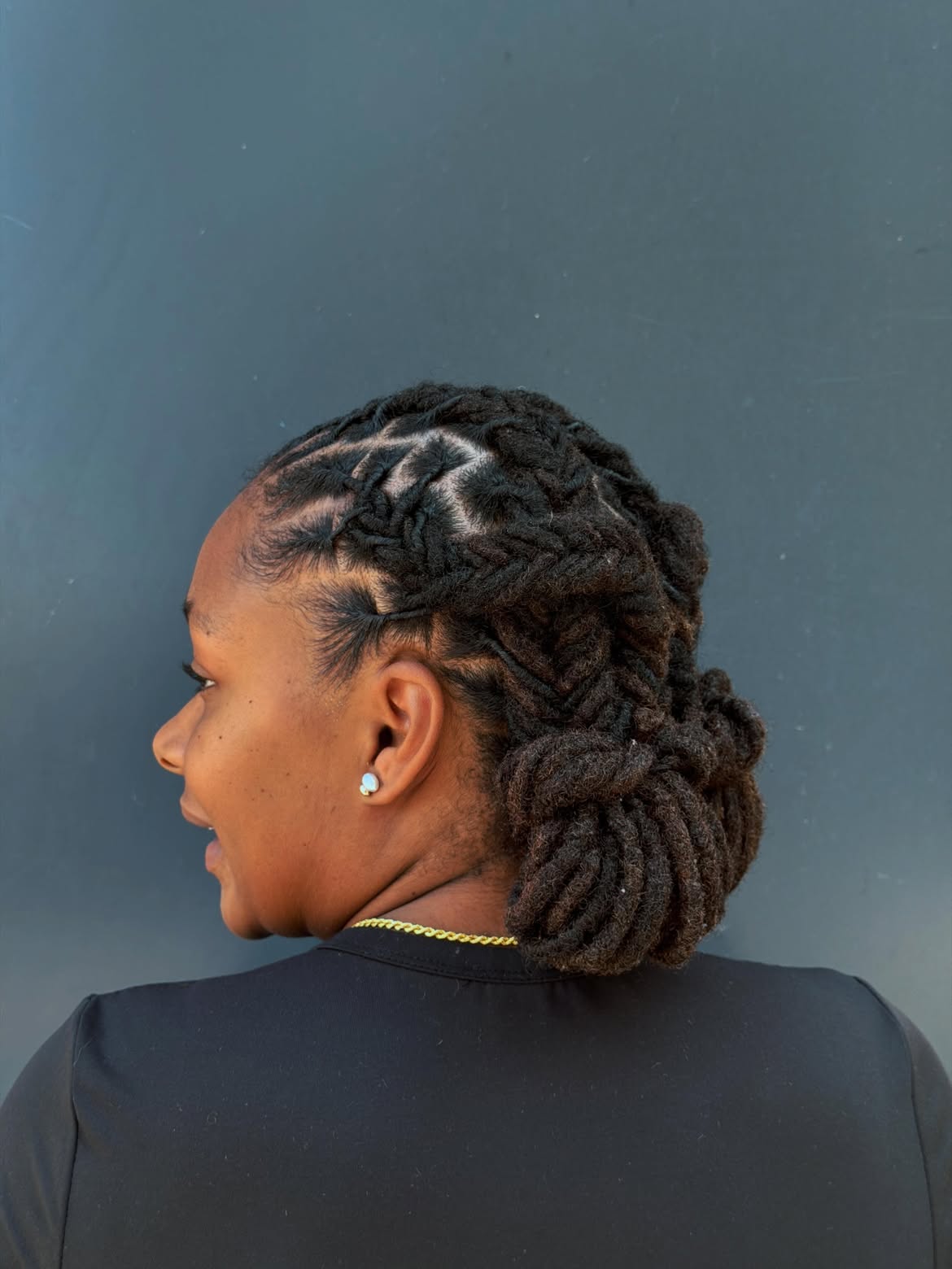 Intricate Braided Loc Updo With Geometric Parting