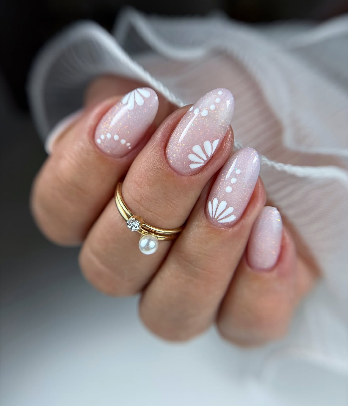 Shimmering Nude Almond Nails With White Hand Painted Art