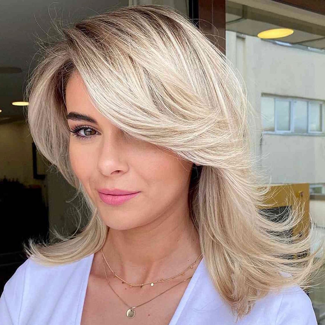 Voluminous Blonde Layers With Side Swept Bangs