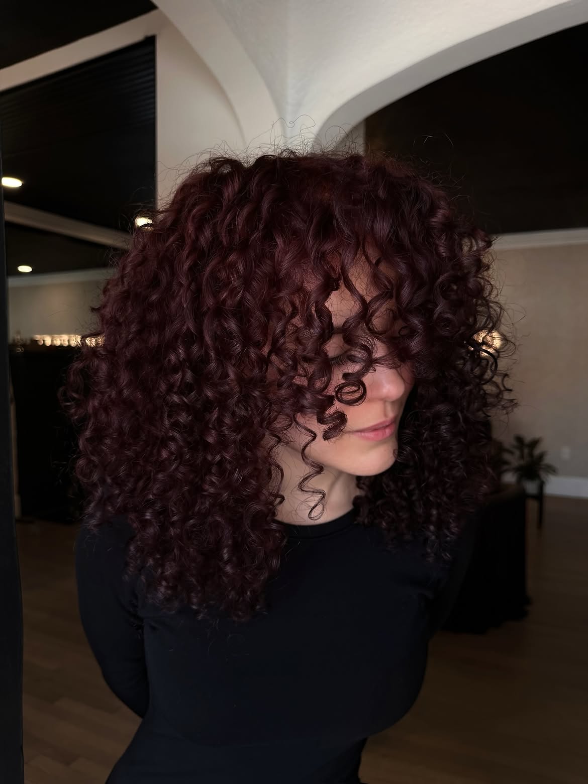 Voluminous Deep Burgundy Curls With Face Framing Layers