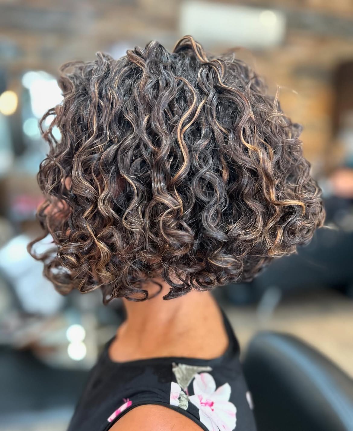 Dimensional Copper Highlights On Curly Chin Length Bob